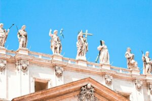 A collection of saint statues stands atop a building